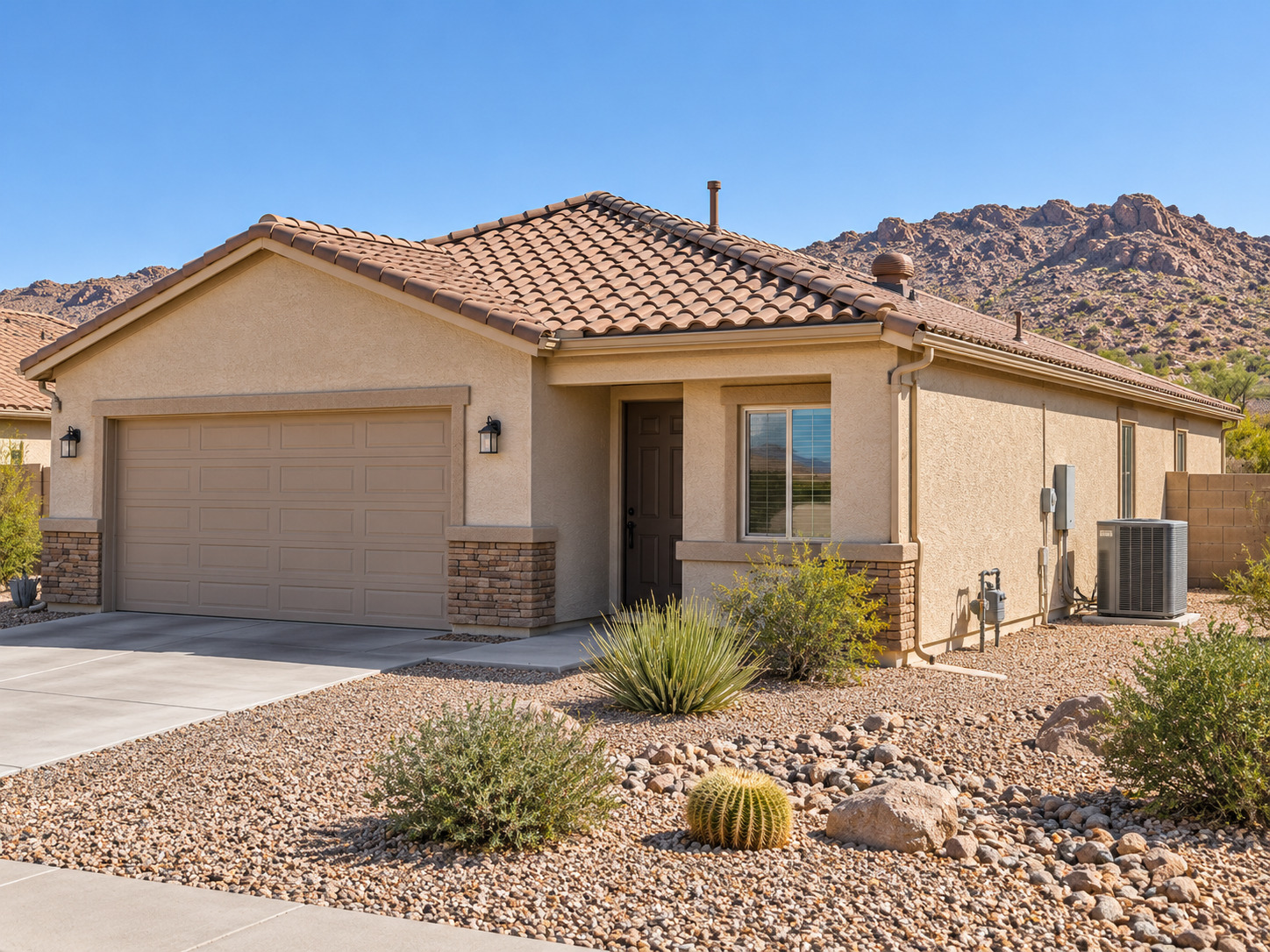 Mohave County home with tile roof, stucco exterior, air-conditioning equipment, and desert landscaping